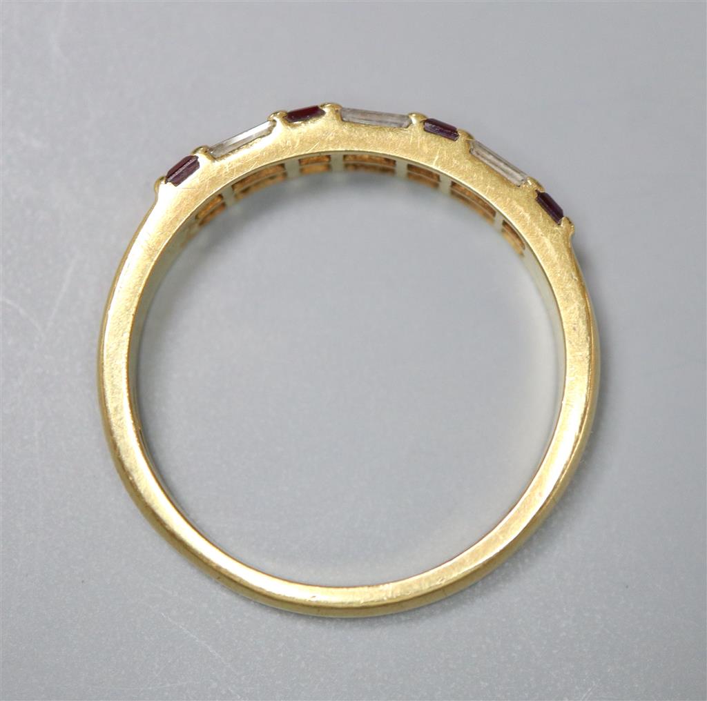 A modern 18ct gold, square cut ruby and baguette cut diamond set half hoop ring, size Q, gross 3.6 grams.